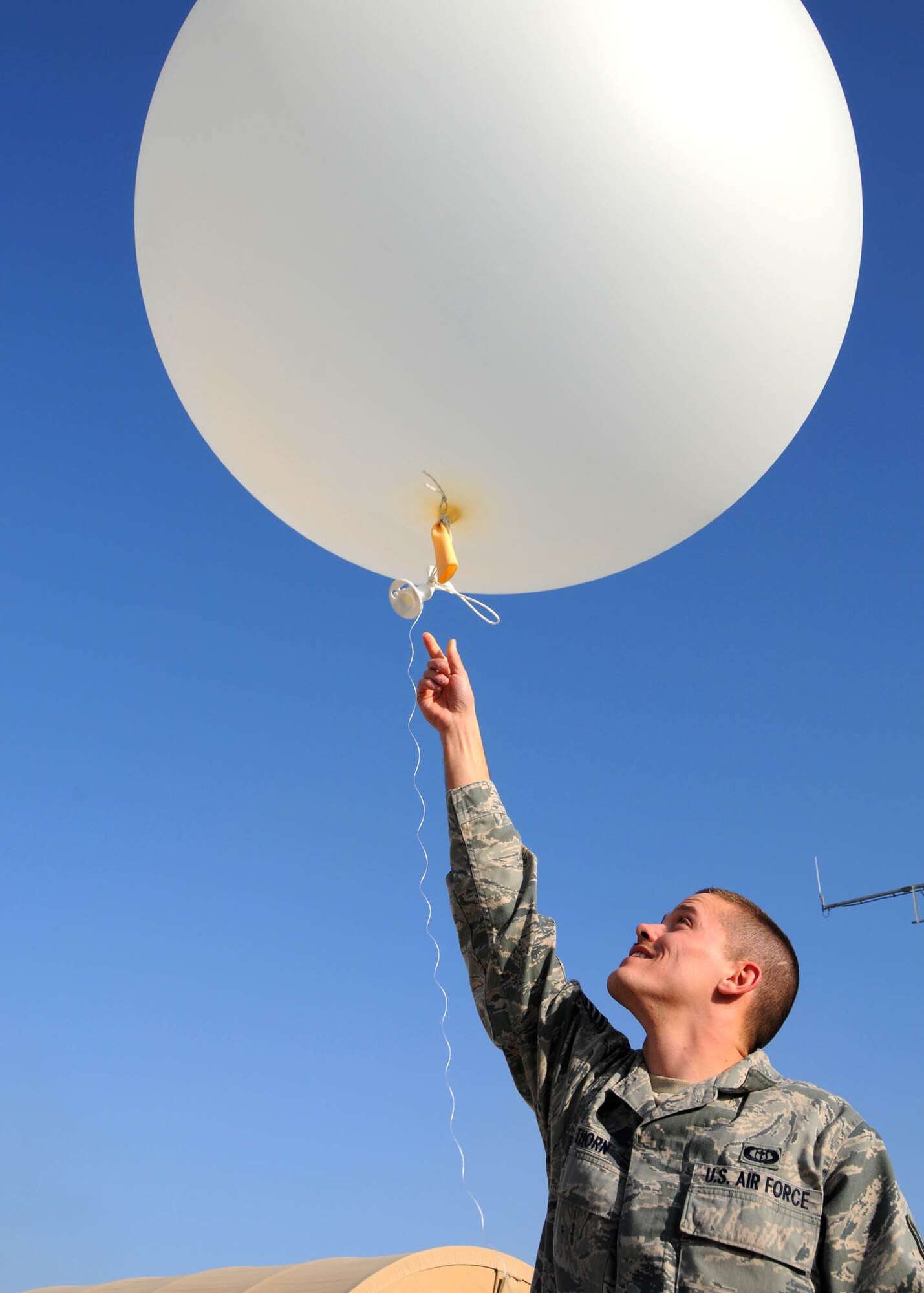 Staff Sgt. Joshua Thorn, 451st Expeditionary Operations Support Squadron weather observer, releases the twice-daily weather balloon at Kandahar Airfield, Afghanistan, Feb. 14, 2012. The weather balloon measures atmospheric pressure, temperature and humidity and transmits the information back to the weather station using a radiosonde attached to the balloon. (U.S. Air Force photo by Staff Sgt. Heather Skinkle)