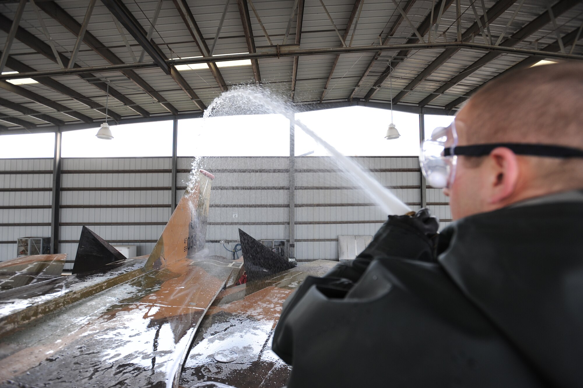 U.S. Air Force Airman 1st Class Jeffrey Simmons, 20th Equipment Maintenance Squadron crash recovery, sprays down the top of the F-111E Aardvark at Shaw Air Force Base, S.C., Feb. 8, 2012. Before the Aardvark is displayed with the other historical aircraft at the front gate, it had to be washed and restored. (U.S. Air Force photo by Senior Airman Tabatha McCarthy/Released)