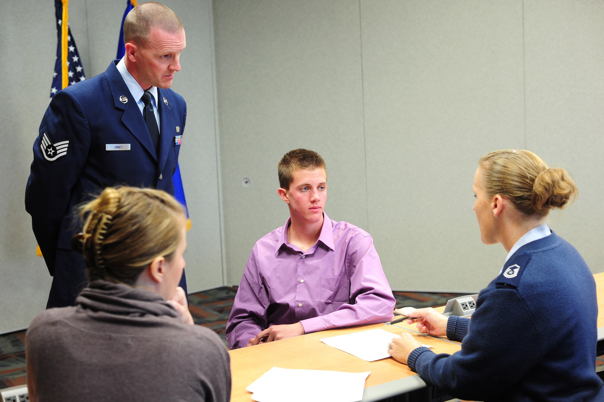 Staff Sgt. Conrad Jones, 310th Force Support Squadron Unit Training Manager, and his wife Sonja, listen to Master Sgt. Cherri Marin, Air Force Reserve Recruiter, explain to their son, Brenden Jacobs Jones, about his first enlisted contract. Moments later, Staff Sgt. Jones and his son Brenden recited the enlisted oath together, February 13. (U.S. Air Force photo/Tech. Sgt. Nicholas B. Ontiveros)