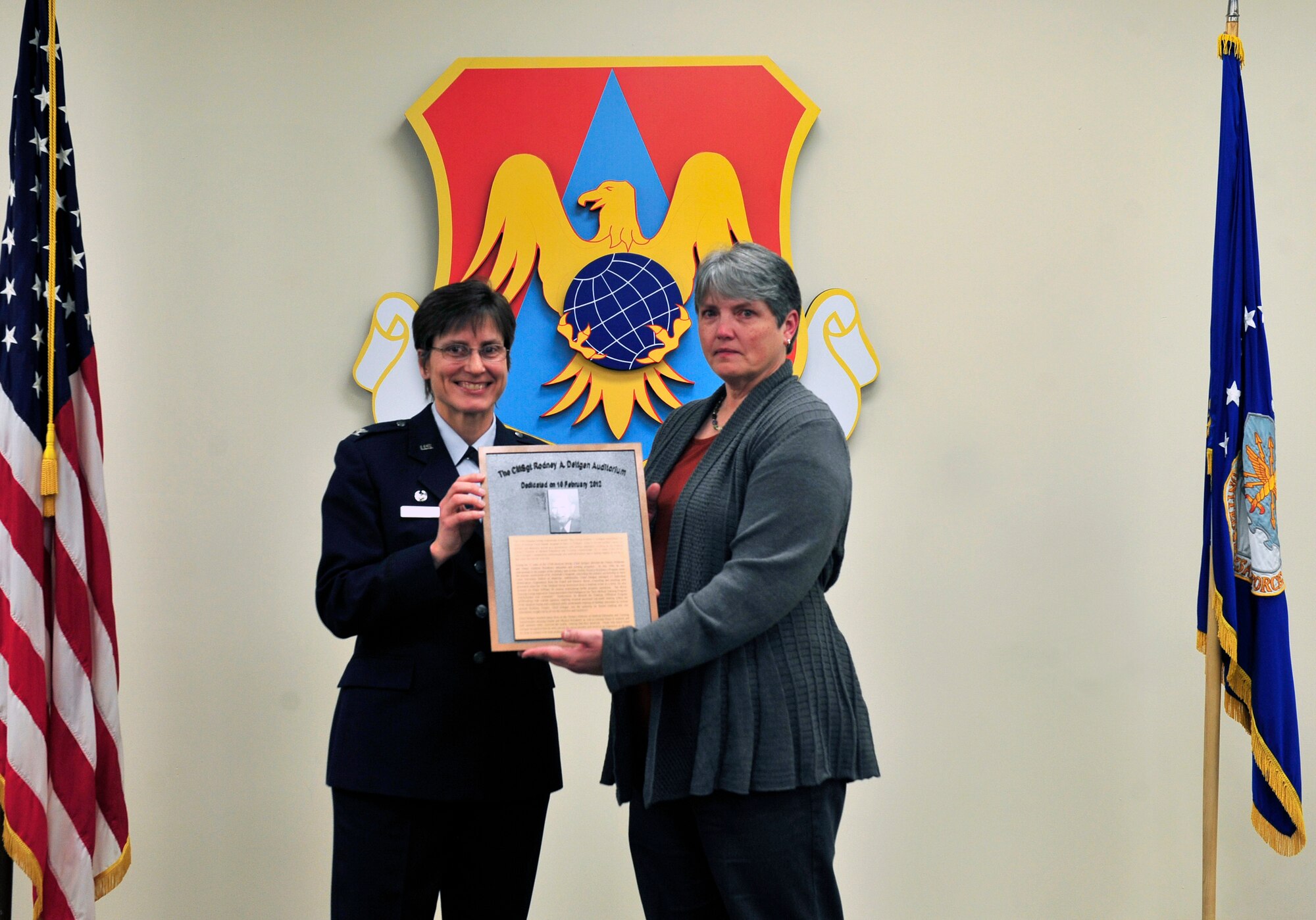 Col. Jill Sterling, 375th Medical Group commander presents Gloria Lima, daughter of retired chief Rodney Deltgen with a plaque during a the hospital auditorium dedication to her father Feb. 10. (U.S. Air Force photo/ Staff Sgt. Stephenie Wade)
