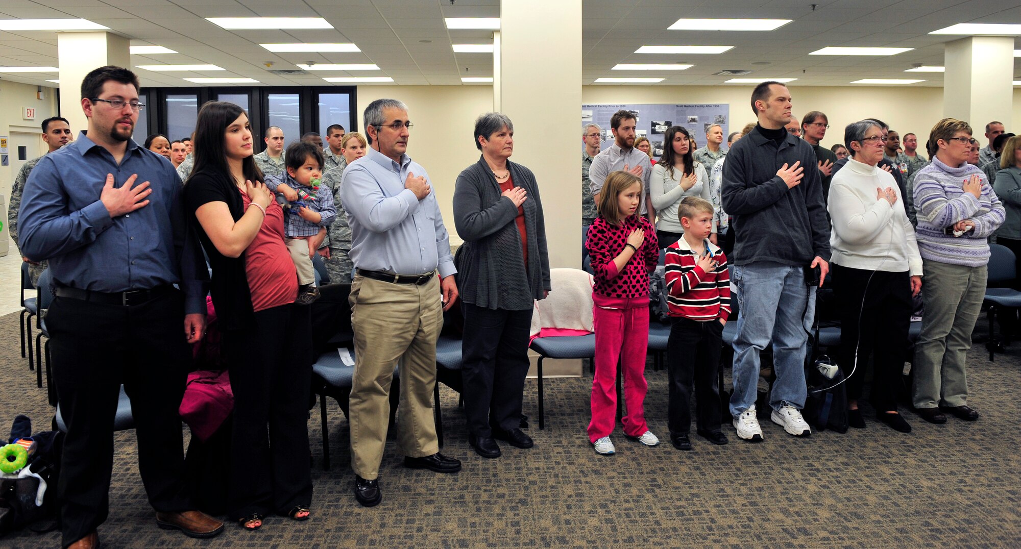 Seventeen Family members of the late Rodney Deltgen stand during the singing of the National Anthem in the hospital auditorium Feb. 10. (U.S. Air Force photo/ Staff Sgt. Stephenie Wade)
