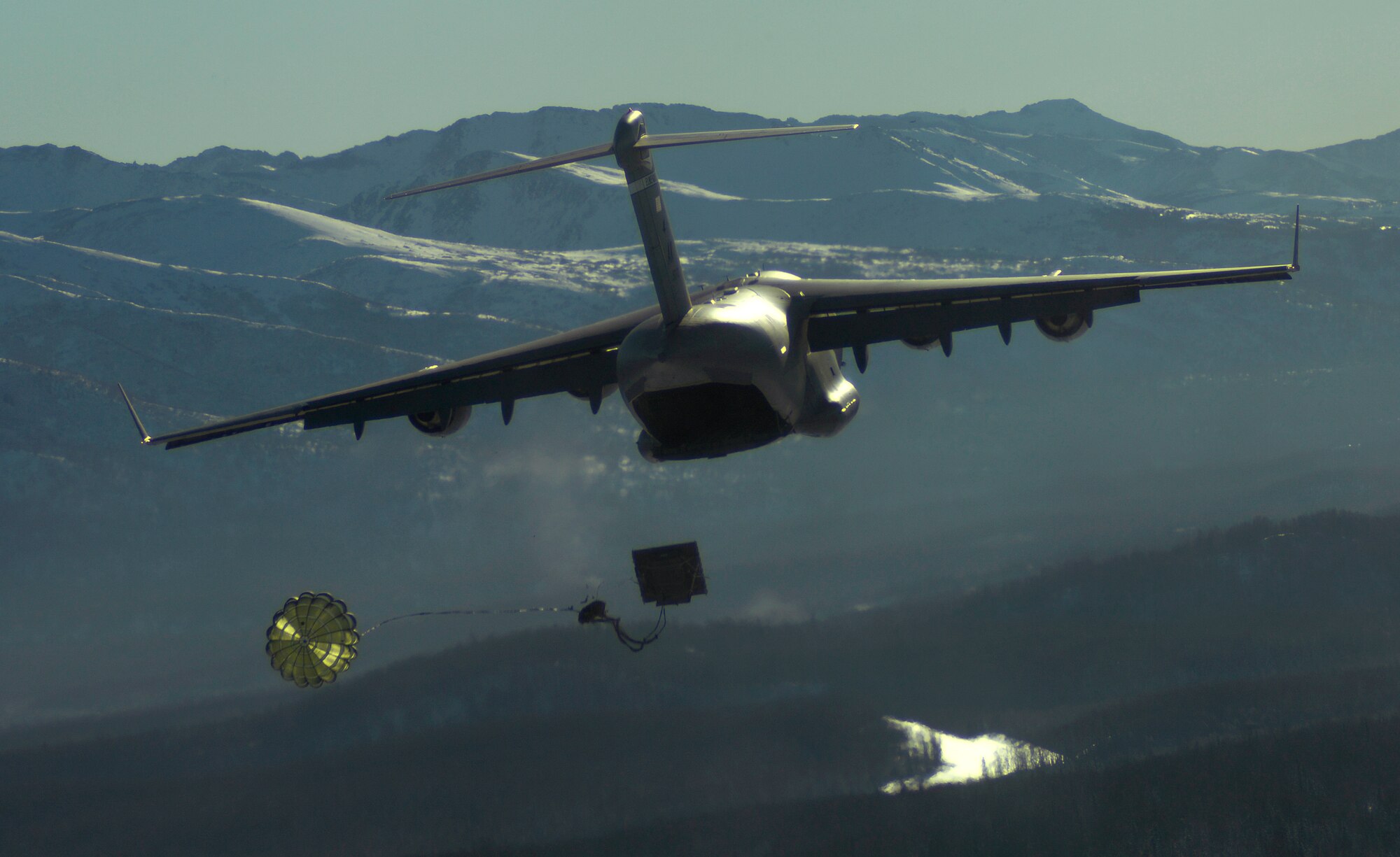 A C-17 Globemaster III from the 517th Airlift Squadron drops heavy equipment over Malemute Drop Zone, Feb. 7. (U.S. Air Force photo/Tech Sgt. Brian Ferguson)