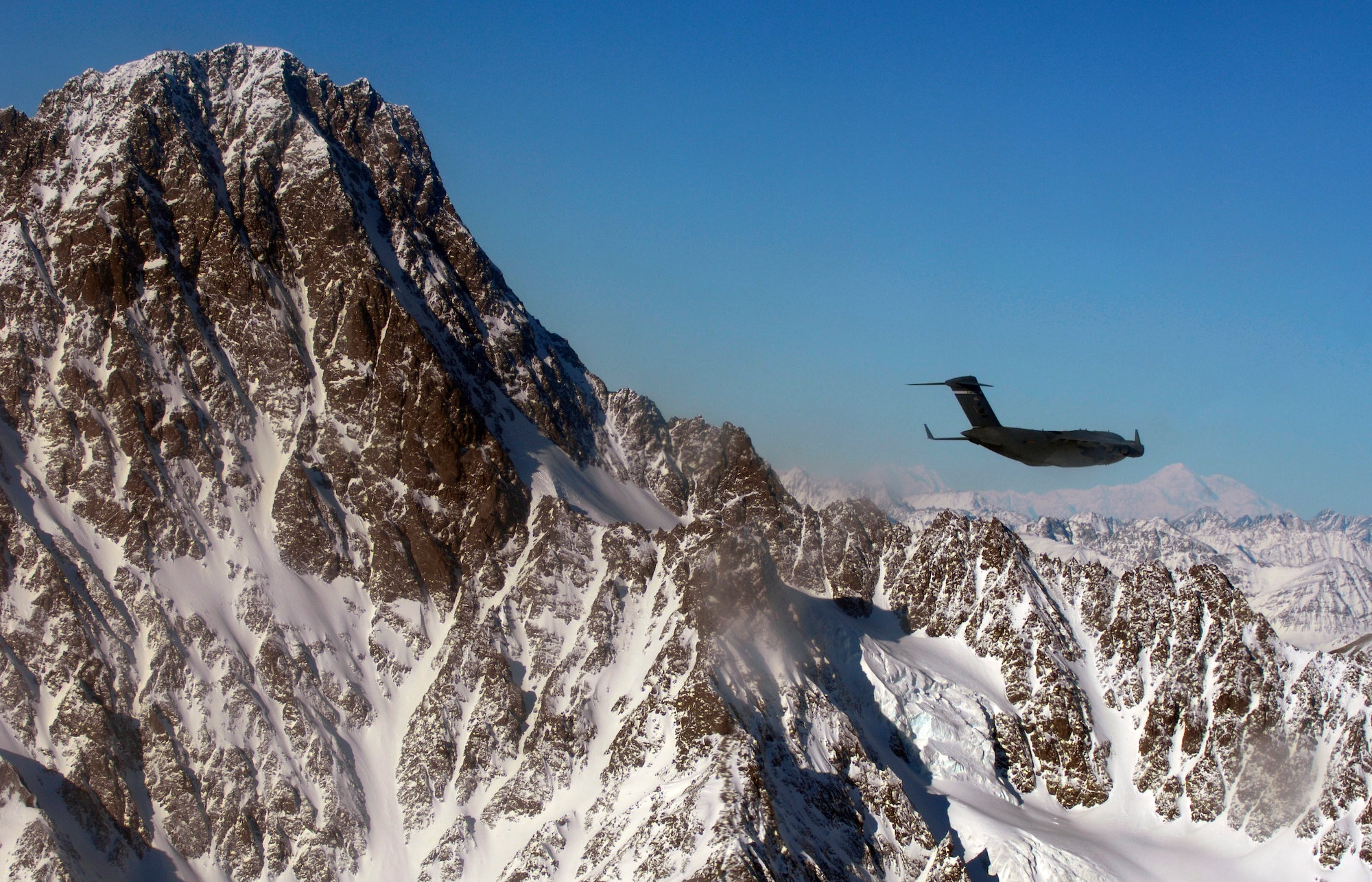 A C-17 Globemaster III from the 517th Airlift Squadron flies over an Alaska mountain range, before dropping Soldiers from the 6th Engineer Battalion (Combat) (Airborne) Feb. 7. (U.S. Air Force photo/Tech Sgt. Brian Ferguson)