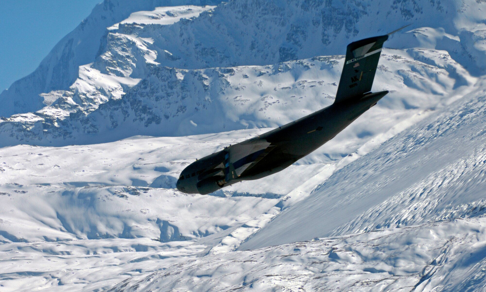 A C-17 Globemaster III from the 517th Airlift Squadron flies over an Alaska mountain range, before dropping Soldiers from the 6th Engineer Battalion (Combat) (Airborne) Feb. 7. (U.S. Air Force photo/Tech Sgt. Brian Ferguson)