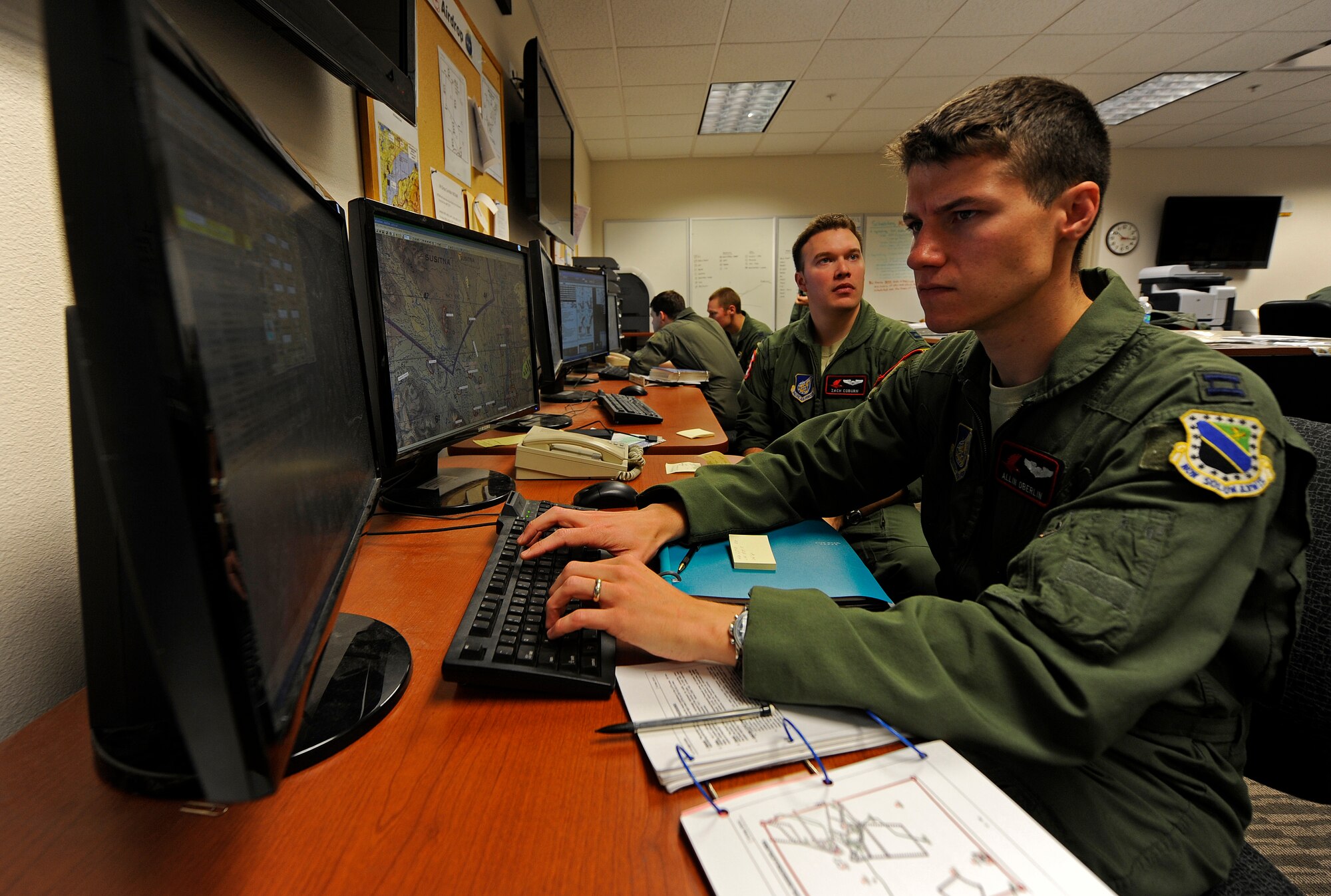 Captain Allin Oberlin, front, and Capt. Zach Coburn plan a heavy equipment and personnel air drop, Feb. 6.  Oberlin and Coburn are C-17 Globemaster III pilots with the 517th Airlift Squadron, Joint Base Elmendorf-Richardson, Alaska. (U.S. Air Force photo/Tech Sgt. Brian Ferguson)