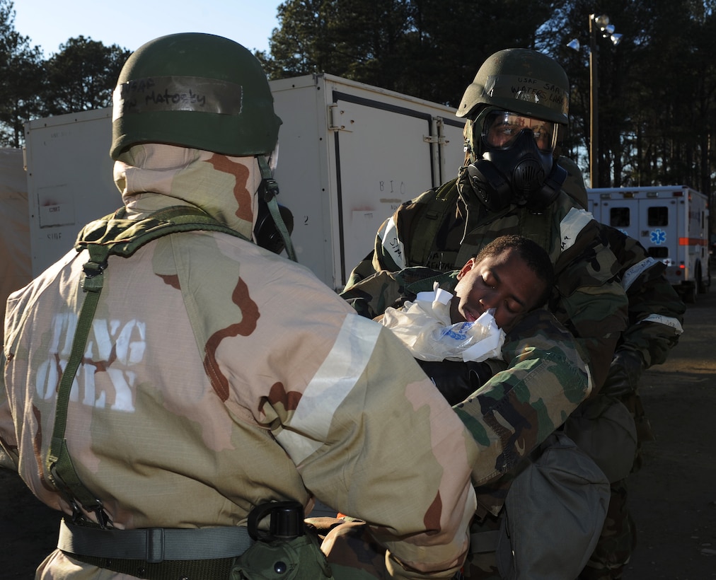 U.S. Air Force Staff Sgt. Brian Matosky, 633rd Force Support Squadron mortuary technician, and Senior Airman Larentae Waters, 633rd FSS personnelist, carry a simulated victim to a medical tent during the phase II operational readiness exercise at Langley Air Force Base, Va., Feb. 15, 2012. Airmen wear the gas mask during the phase II ORE as a means to improve their skills should an attack occur while in a deployed environment. (U.S. Air Force photo by Airman 1st Class Teresa Cleveland/Released)