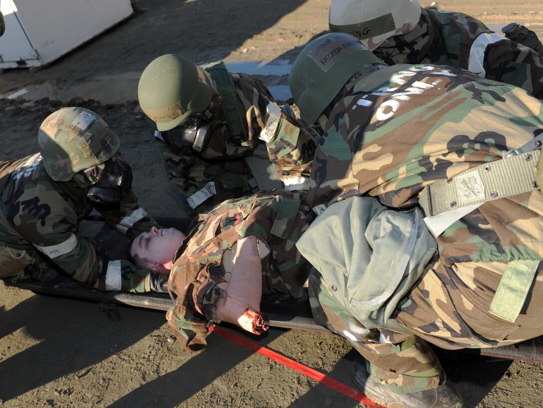 Airmen from the 633rd Medical Group lift a simulated victim onto a litter during the phase II operational readiness exercise at Langley Air Force Base, Va., Feb. 15, 2012. The phase II ORE is designed to simulate a deployed environment and test combat abilities, such as self-aid buddy care, and post-attack reconaissance. (U.S. Air Force photo by Airman 1st Class Teresa Cleveland/Released)