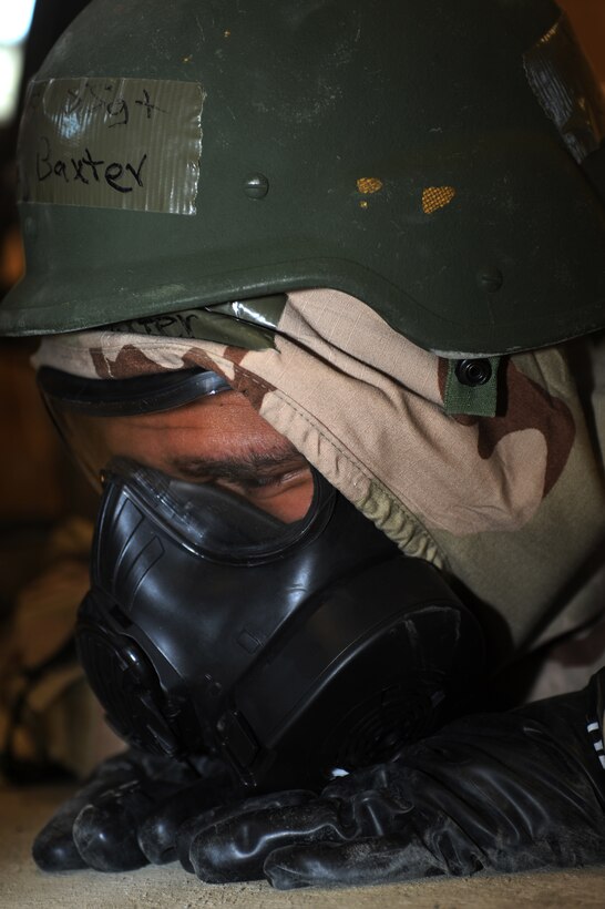 U.S. Air Force Staff Sgt. Gregory Baxter, 633rd Air Base Wing Judge Advocate General paralegal, prepares for simulated missile impact during the phase II operational readiness exercise at Langley Air Force Base, Va., Feb. 15, 2012. Airmen wear the gas mask during a phase II ORE to prepare for potential chemical attacks. (U.S. Air Force photo by Airman 1st Class Teresa Cleveland/Released)