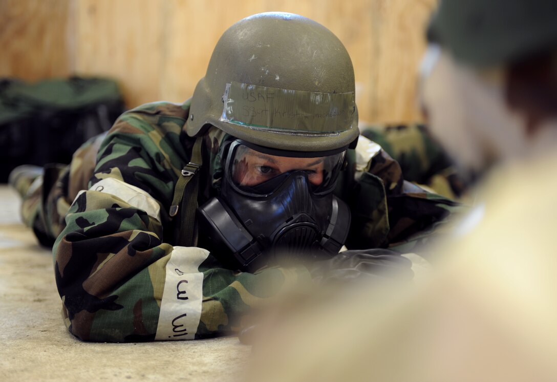 U.S. Air Force Staff Sgt. Kristine Mackeown, 633rd Air Base Wing Chapel chaplain assistant, takes cover during a simulated missile attack during the phase II operational readiness exercise at Langley Air Force Base, Va., Feb. 15, 2012. A phase II ORE is designed to prepare Airmen for deployed operations, including potential chemical attacks. (U.S. Air Force photo by Airman 1st Class Teresa Cleveland/Released)