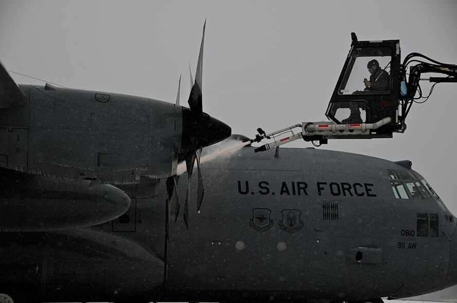 A C-130 Hercules, assigned to the 911th Airlift Wing, is de-iced before being flown on a training mission, Feb. 12, 2012. Aircraft de-icing is a process in which liquid solutions are sprayed onto an aircraft which enables a defrosting process, but also prevents future precipitation from freezing to the airplane. (U.S. Air Force photo by Senior Airman Joshua J. Seybert/Released)