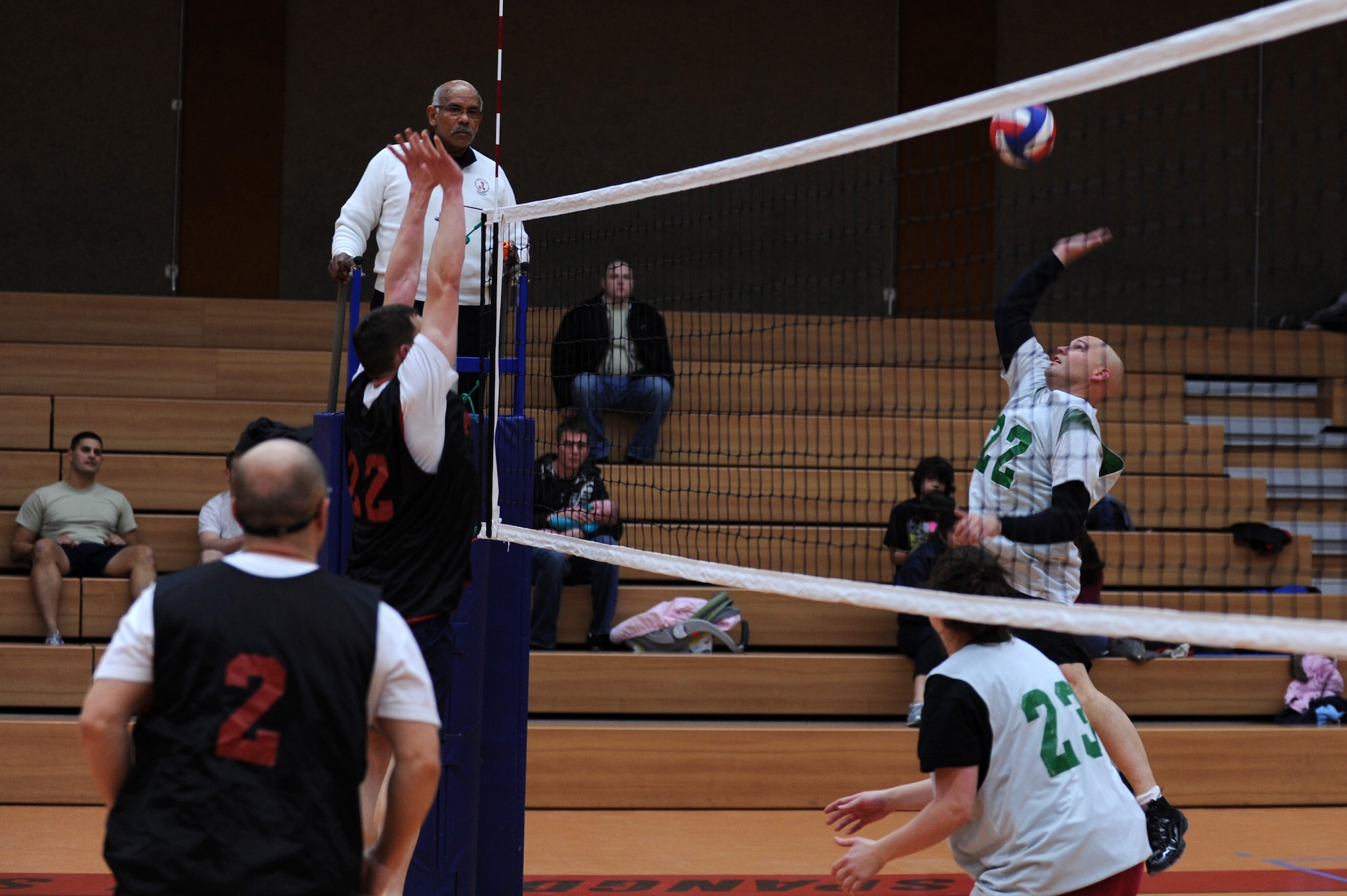 SPANGDAHLEM AIR BASE, Germany – Troy Soeder, 606th Air Control Squadron, number 22, jumps to hit the volleyball over 52nd Force Support squadron defenders during an intramural volleyball game at the Skelton Memorial Fitness Center here Feb. 15. FSS defeated ACS in two sets, 25-16 and 26-24.  This match kicked off the intramural volleyball season, and games will be played Monday – Thursday beginning at 6:30 p.m. at the fitness center. (U.S. Air Force photo by Airman 1st Class Matthew B. Fredericks/Released)