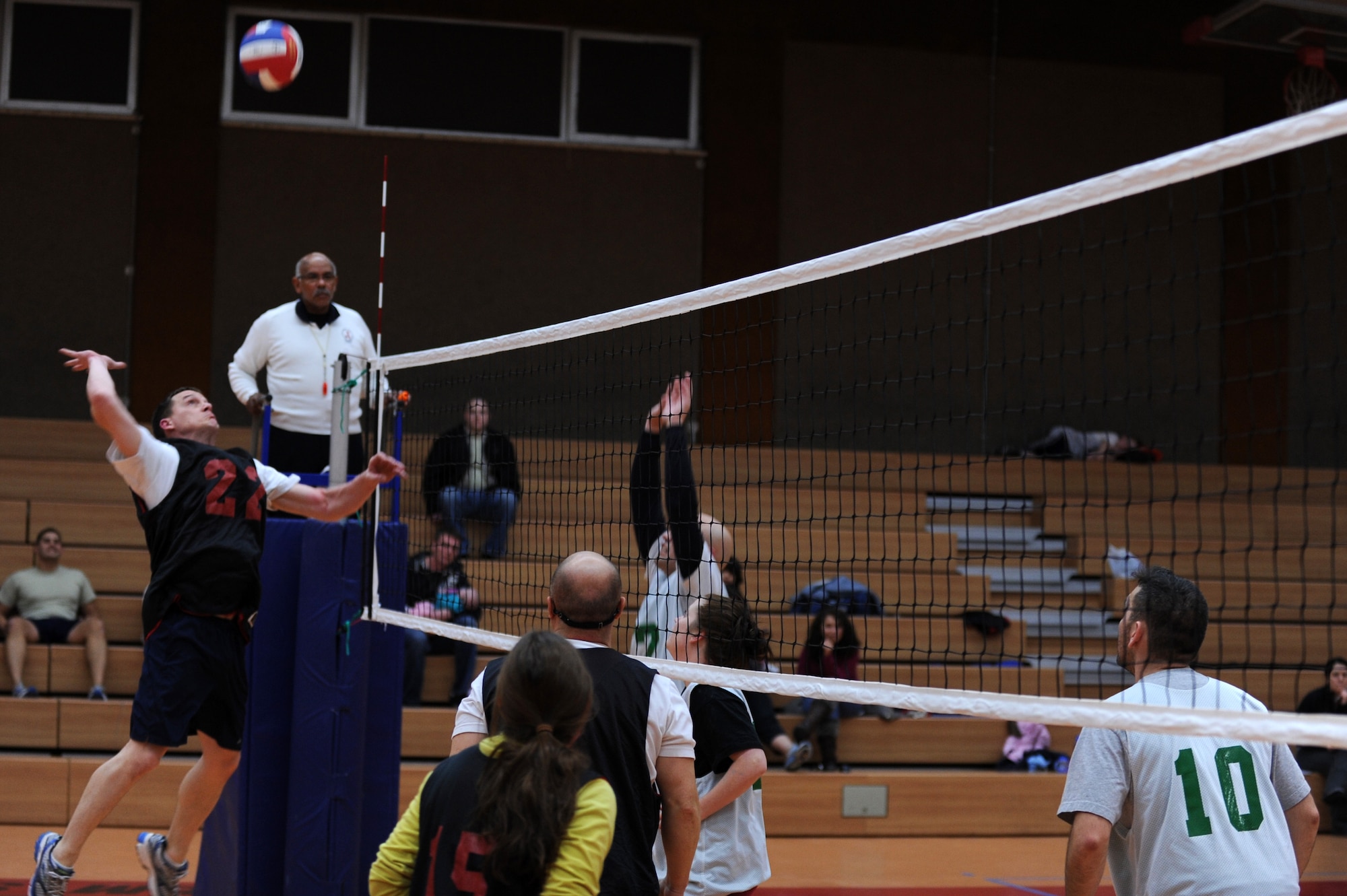 SPANGDAHLEM AIR BASE, Germany – Kenneth Phillips, 52nd Force Support Squadron, number 22, jumps to spike the volleyball over 606th Air Control Squadron defenders during an intramural volleyball game at the Skelton Memorial Fitness Center here Feb. 15. FSS defeated ACS in two sets, 25-16 and 26-24.  This match kicked off the intramural volleyball season, and games will be played Monday – Thursday beginning at 6:30 p.m. at the fitness center. (U.S. Air Force photo by Airman 1st Class Matthew B. Fredericks/Released)