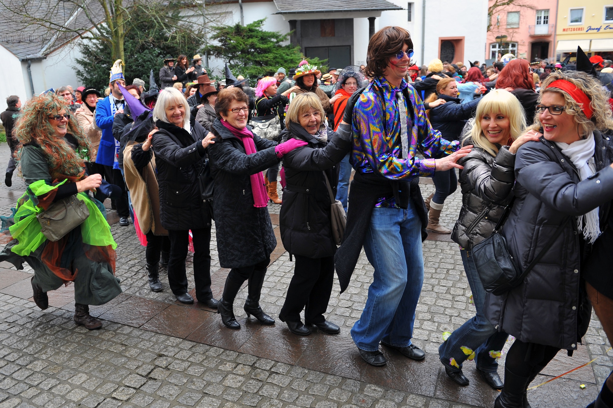 BITBURG, Germany – Local German nationals and American military service members participate in a dance line during Ladies Fasching Day celebrations at the Bitburg Town Hall here Feb. 16. Ladies Fasching Day is a German celebration where women “take over” the city for the day. Once the ladies have “taken over” the city hall, the celebrations begin with dancing and parading throughout the city. The traditional Fasching celebrations begin the Thursday prior to Lent at the 11th minute past the 11th hour, continue until Ash Wednesday and allow people to indulge before the Lent season. (U.S. Air Force photo by Airman 1st Class Dillon Davis/Released)