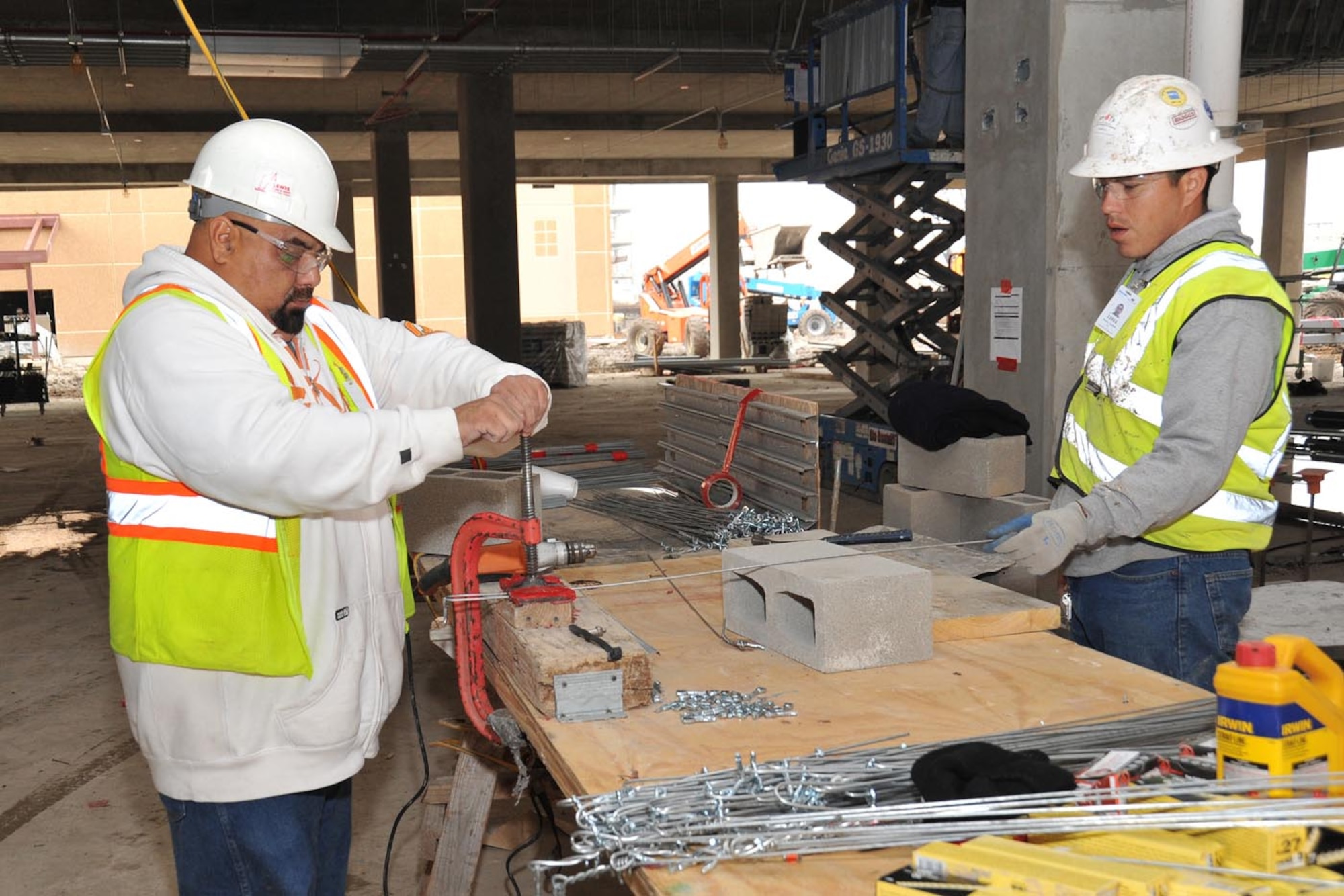 Contract employees working to finish the 37th Training Wing’s new Airman Training Complex No. 1 prepare suspension wire for ceiling tile Feb. 7 at the Joint Base San Antonio-Lackland construction site. ATC No. 1 is tentatively scheduled for completion later this summer. (U.S. Air Force photo/Alan Boedeker)