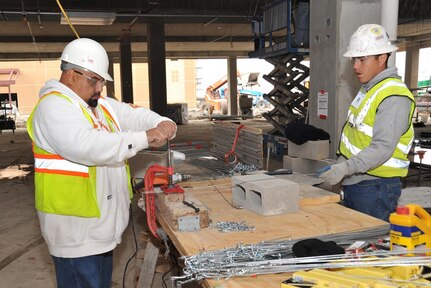 Contract employees working to finish the 37th Training Wing’s new Airman Training Complex No. 1 prepare suspension wire for ceiling tile Feb. 7 at the Joint Base San Antonio-Lackland construction site. ATC No. 1 is tentatively scheduled for completion later this summer. (U.S. Air Force photo/Alan Boedeker)