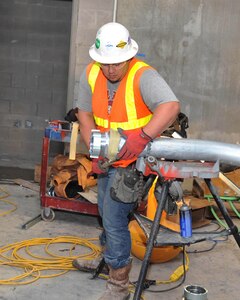 Jesse Gomez, a contract employee working to finish the 37th Training Wing's new Airman Training Complex No. 1, installs a coupler on a piece of conduit Feb. 7 at the Airman Training Complex No. 1 construction site. The complex is tentatively scheduled for completion in late summer. (U.S. Air Force photo/Alan Boedeker)