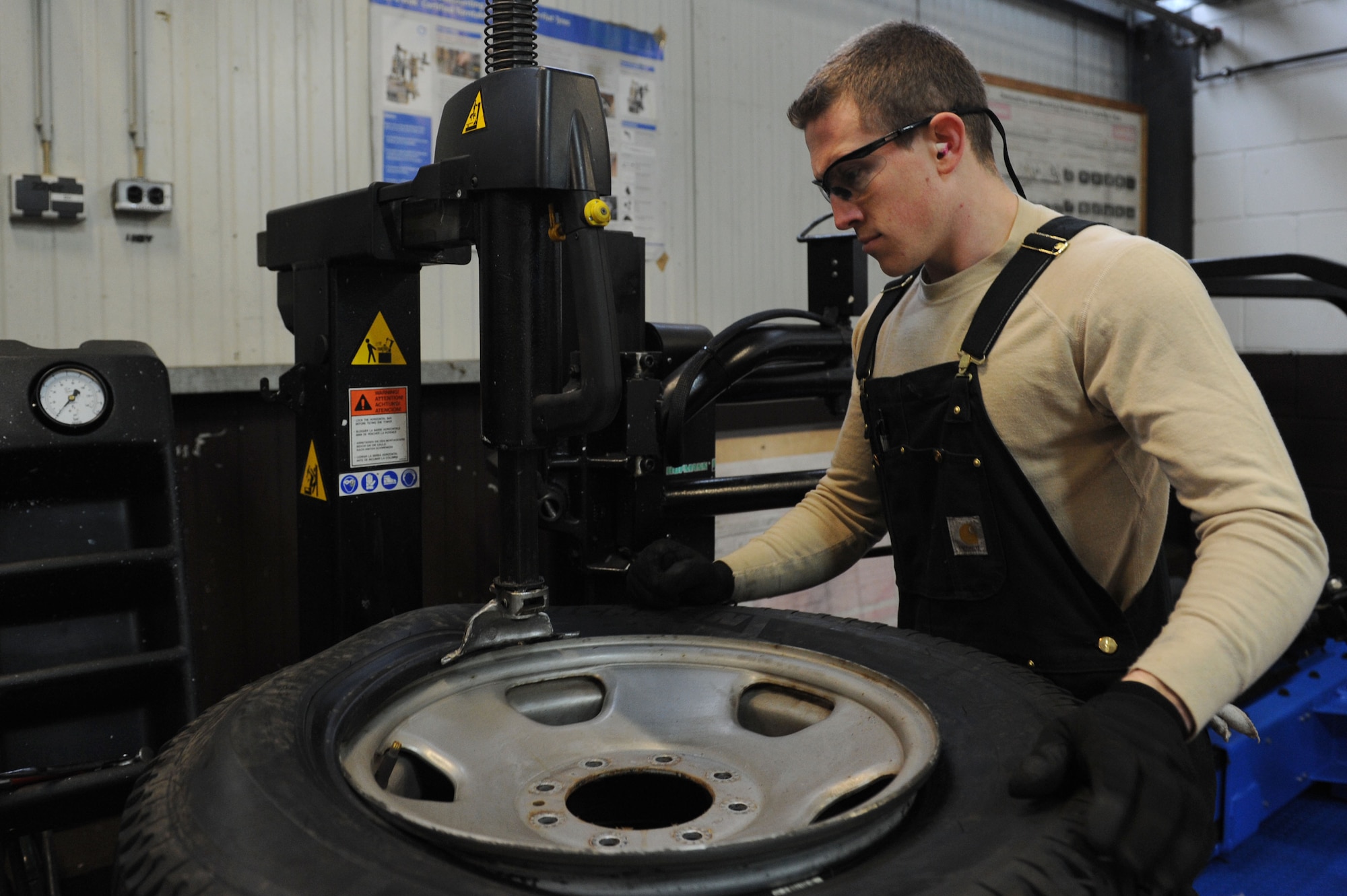 SPANGDAHLEM AIR BASE, Germany – Senior Airman Brandon Adams, 52nd Logistics Readiness Squadron vehicle maintenance journeyman, putting on a tire to the rim during a removing process at the tire shop in Bldg. 111 here Feb. 15. The process allows the issuing of new tires to government-owned vehicles keeping the vehicle safe and serviceable. The vehicle management flight continuously services and maintains more than 900 government-owned vehicles for Spangdahlem, Bitburg and all the geographically - separated units. (U.S. Air Force photo by Senior Airman Christopher Toon/Released) 