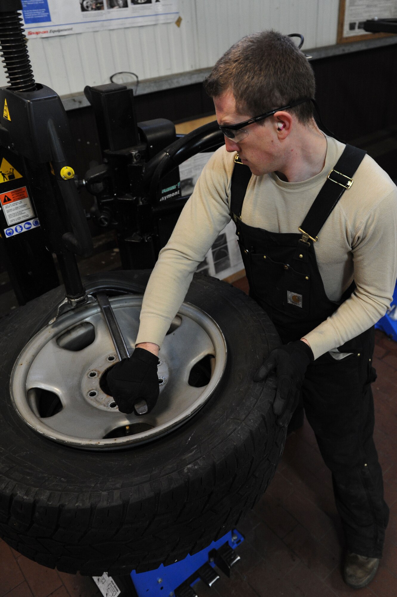 SPANGDAHLEM AIR BASE, Germany – Senior Airman Brandon Adams, 52nd Logistics Readiness Squadron vehicle maintenance journeyman, uses a pry-bar to demount a tire during a tire demounting process at the tire shop in Bldg. 111 here Feb. 15. The process allows the issuing of new tires to government-owned vehicles keeping the vehicle safe and serviceable. The vehicle management flight continuously services and maintains more than 900 government-owned vehicles for Spangdahlem, Bitburg and all the geographically - separated units. (U.S. Air Force photo by Senior Airman Christopher Toon/Released)