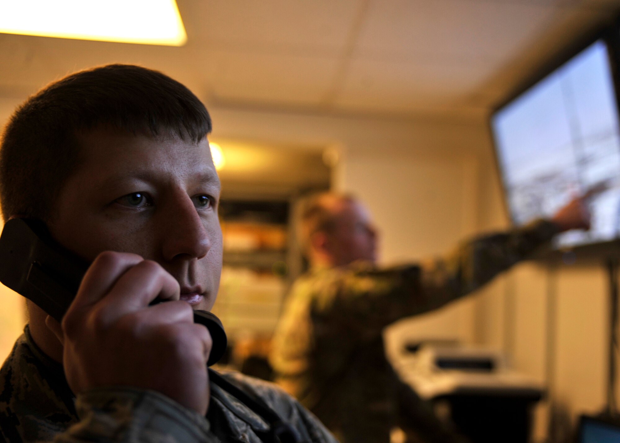BAGRAM AIRFIELD, Afghanistan—Staff Sgt. Leonard Sherwood reports surveillance data to security forces units at Bagram Airfield, Afghanistan, Feb. 16, 2012. Sherwood is a controller with the 455th Expeditionary Security Forces Squadron and is deployed from Beale Air Force Base, Calif. Controllers remotely monitor Bagram’s perimeter for potential threats and report all security violations to security forces, allowing them to take defensive action. (U.S. Air Force photo/Airman 1st Class Ericka Engblom)