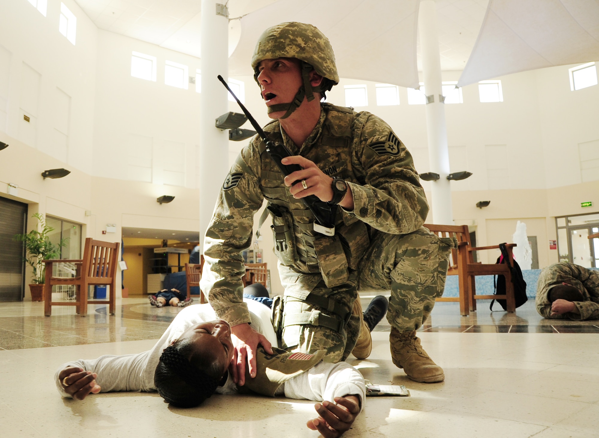 Staff Sgt. William Vernon, 379th Expeditionary Security Forces Squadron ground defense specialist, calls for medical assistance over the radio in the Blatchford-Preston Complex Mall during an active shooter exercise Feb. 14, 2012. The exercise tested the defense and response capabilities of U.S. service members and coalition partners on the installation. (U.S. Air Force photo/Senior Airman Michael Charles)