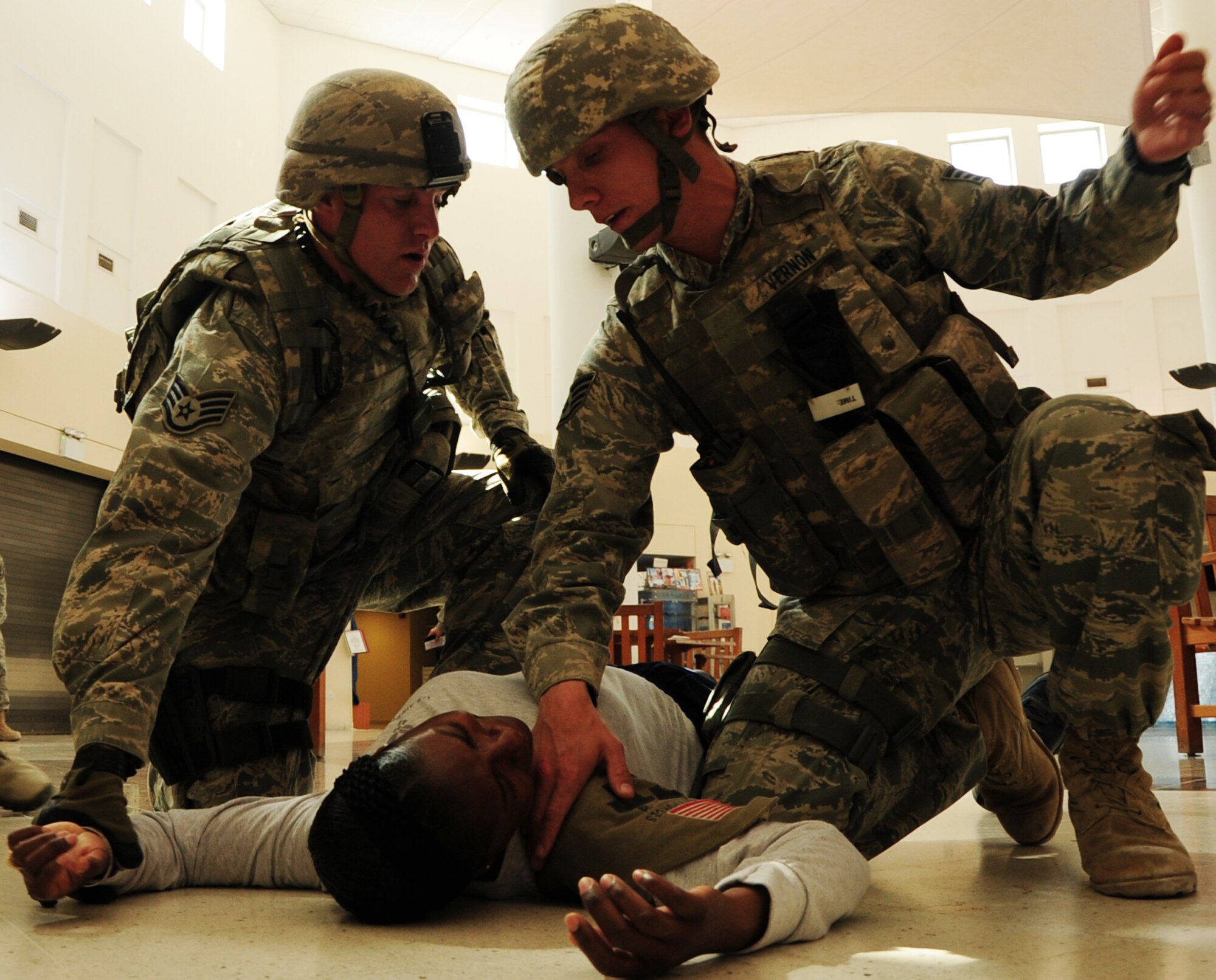Staff Sgt. Zachary Coltey and Staff Sgt. William Vernon, 379th Expeditionary Security Forces Squadron ground defense specialists, conduct first aid on Master Sgt. Chasity Lee, 379th Air Expeditionary Wing equal opportunity specialist and simulated victim, during the active shooter exercise Feb. 14, 2012. The exercise tested the defense and response capabilities of U.S. service members and coalition partners on the installation. (U.S. Air Force photo/Senior Airman Michael Charles)