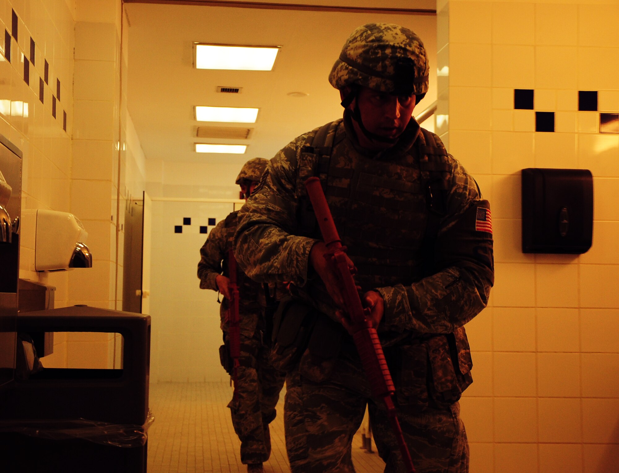 Tech. Sgt. Jamen Berry, 379th Expeditionary Security Forces Squadron specialist, and Staff Sgt. William Vernon, 379 ESFS specialist, conduct a sweep of the male’s restroom in the Blatchford-Preston Complex Mall during an active shooter exercise Feb. 14, 2012. The exercise tested the defense and response capabilities of U.S. service members and coalition partners on the installation. (U.S. Air Force photo/Senior Airman Michael Charles)