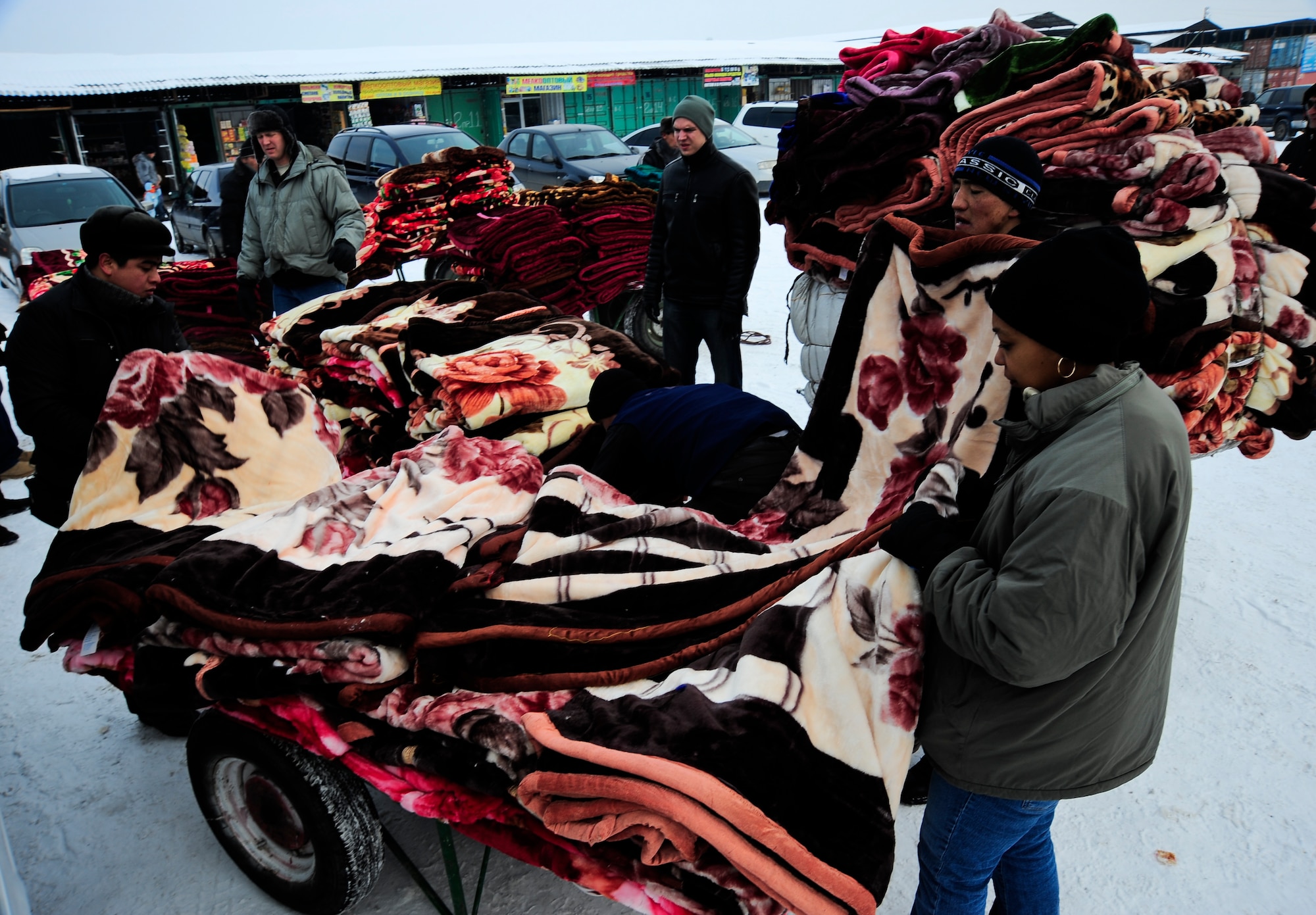 Capt. Kay Stern (right), along with local vendors and the Airmen from the Transit Center at Manas, count an order of blankets Feb. 6, 2012, during an Operation Warm and Dry purchase at Dordoy Market in Bishkek, Kyrgyzstan.  More than 600 blankets and coats were purchased totaling $10,000 in revenue for Kyrgyz citizens. Stern is the 376th Air Expeditionary Theater Security Cooperation division social cultural branch chief. She is deployed from Kirtland Air Force Base, N.M. (U.S. Air Force Photo/Staff Sgt. Angela Ruiz)