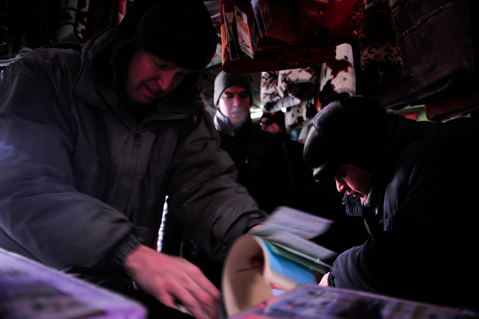Capt. Michael Reimers writes a contract Feb. 6, 2012, with Akmol, a blanket vendor, while Staff Sgt. Igor Pogrebnyak interprets the transaction in the Dordoy Market in Bishkek, Kyrgyzstan.  The contract is on behalf of Operation Warm and Dry to purchase blankets from Akmol. Reimers is a South Central Asia for humanitarian assistance contracting officer with U.S. Central Command deployed to the Transit Center from Hill Air Force Base, Utah. Pogrebnyak is a host-nation liaison with the 376th Air Expeditionary Wing deployed from Creech AFB, Nev. (U.S. Air Force Photo/Staff Sgt. Angela Ruiz)