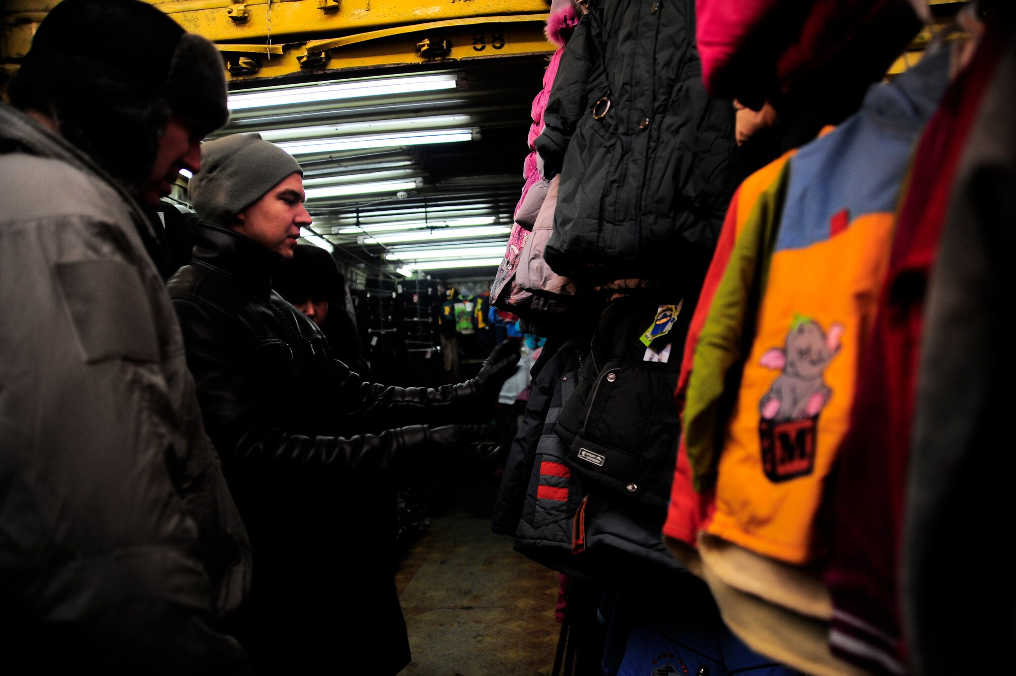 Staff Sgt. Igor Progrebnyak and Capt. Michael Reimers look for coats in the Dordoy Market Feb. 6, 2012, during an Operation Warm and Dry purchasing trip in Bishkek, Kyrgyzstan. The coats and blankets purchased for Warm and Dry are from local vendors in Kyrgyzstan. Warm and Dry is a Transit Center at Manas humanitarian assistance project which provides blankets and coats to "at-risk" populations of Kyrgyzstan. Pogrebnyak is a host-nation liaison with the 376th Air Expeditionary Wing deployed from Creech Air Force Base, Nev. Reimers is a South Central Asia for humanitarian assistance contracting officer with U.S. Central Command deployed to the Transit Center from Hill Air Force Base, Utah.(U.S. Air Force Photo/Staff Sgt. Angela Ruiz)