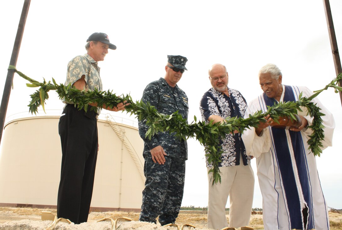U.S. Army Corps of Engineers Chief of Engineering and Construction Todd Barnes, left,  U.S. Navy Fleet Logistics Center Operations Officer Cdr. David Laramie, and Reliable Contracting Group Project Manager Mark Keeling follow the instruction of Reverend David Ka’upu during the traditional untying of the Maile Lei and Ground Breaking Ceremony held Wednesday for the FY11 Alter Fuel Storage Tanks project at Area 11, Joint Base Pearl Harbor-Hickam (JBPHH).  
