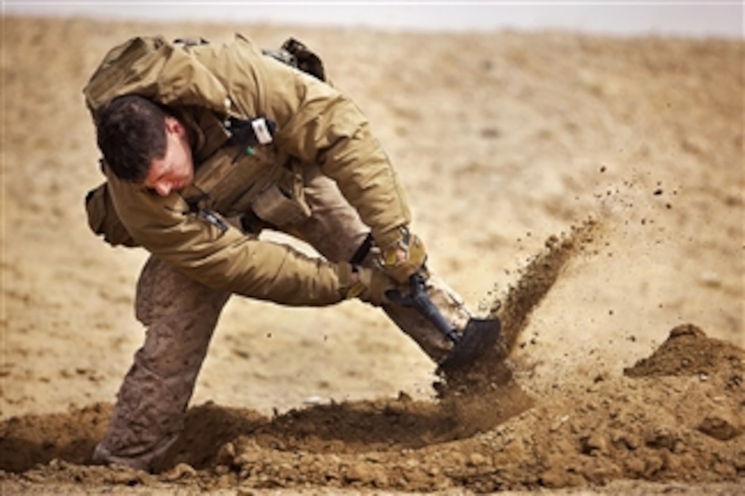 U.S. Marine Lance Cpl. David Manning digs a foxhole at his platoon's defensive position during Operation Shahem Tofan Eagle Storm in the Garmsir district, Helmand province, Afghanistan, on Feb. 12, 2012.  Manning is a machine gunner assigned to Weapons Company, 3rd Battalion, 3rd Marine Regiment.  