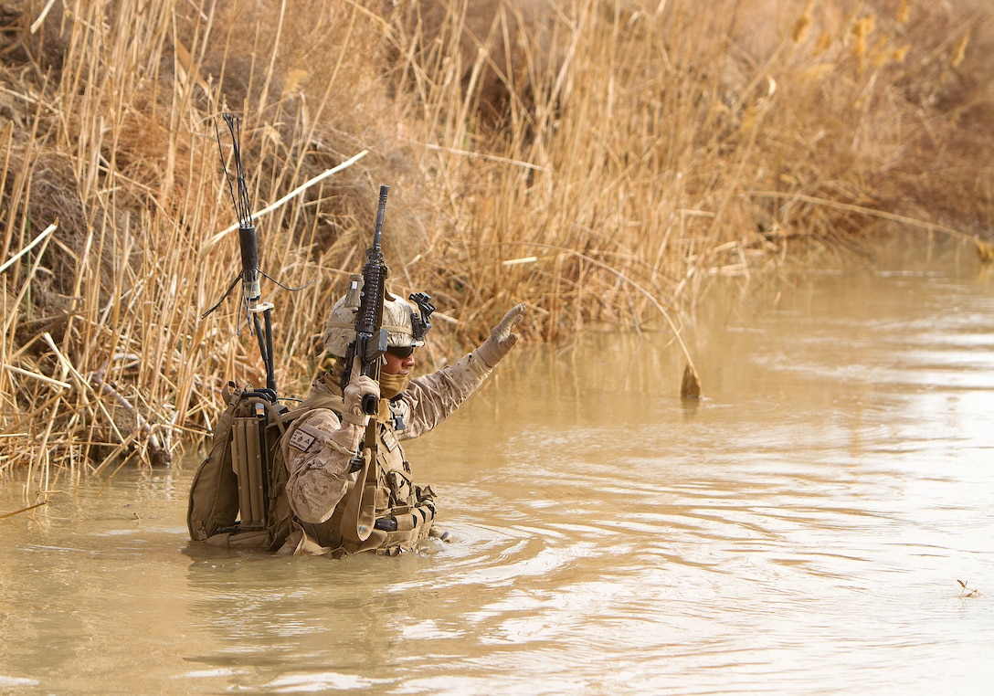 U.S. Marine Lance Cpl. Marcos Castelan, a light armored vehicle crewman with Alpha Company, 1st Light Armored Reconnaissance Battalion, and 19-year-old native of Alvin, Texas, wades through a canal during a patrol here, Feb. 16. Marines and sailors with 1st LAR and India Co., 3rd Battalion, 3rd Marine Regiment, conducted clearing and disrupting operations in and around the villages of Sre Kala and Paygel during Operation Highland Thunder. Marines with 1st LAR led the operation on foot, sweeping for enemy weapons and drug caches through 324 square kilometers of rough, previously unoccupied desert and marshland terrain. Mobile units with1st LAR set up blocking positions and vehicle check points while India Co., 3/3 conducted helicopter inserts to disrupt insurgent freedom of movement.