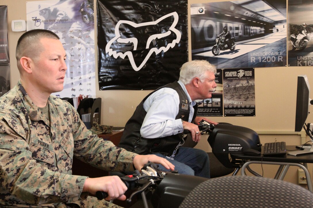 Gunnery Sgt. David L. Pruden, assistant training chief, 1st Marine Division, and Navy veteran use the new motorcycle traffic simulators during the grand opening of the 1st Marine Division Motorcycle Club in the 33 Area, hosted by Semper Ride Motorcycle Safety Campaign, Feb. 17. The 1st Division’s new motorcycle clubhouse, with a classroom and four new motorcycle traffic simulators, can also be utilized by other Marine Corps motorcycle clubs on Camp Pendleton who are without a meeting place for their training and monthly meetings.
