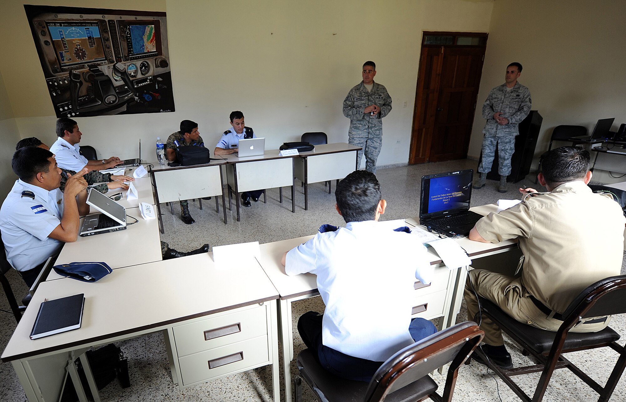 Tech. Sgt. Aaron Carrillo and Staff Sgt. Angel Ortega, 571st Mobility Support Advisory Squadron air advisors, listen to one of the Honduran Air Force Airmen ask a question during the control tower fundamentals seminar Feb. 6.  The MSAS Airmen, representing 15 Air Force specialties, are working side-by-side with Honduran Air Force members in developing seven core competencies of air base defense, air traffic control, aircraft maintenance, aircrew survival, communications, generator maintenance and safety.  (U.S. Air Force photo by Tech. Sgt. Lesley Waters)