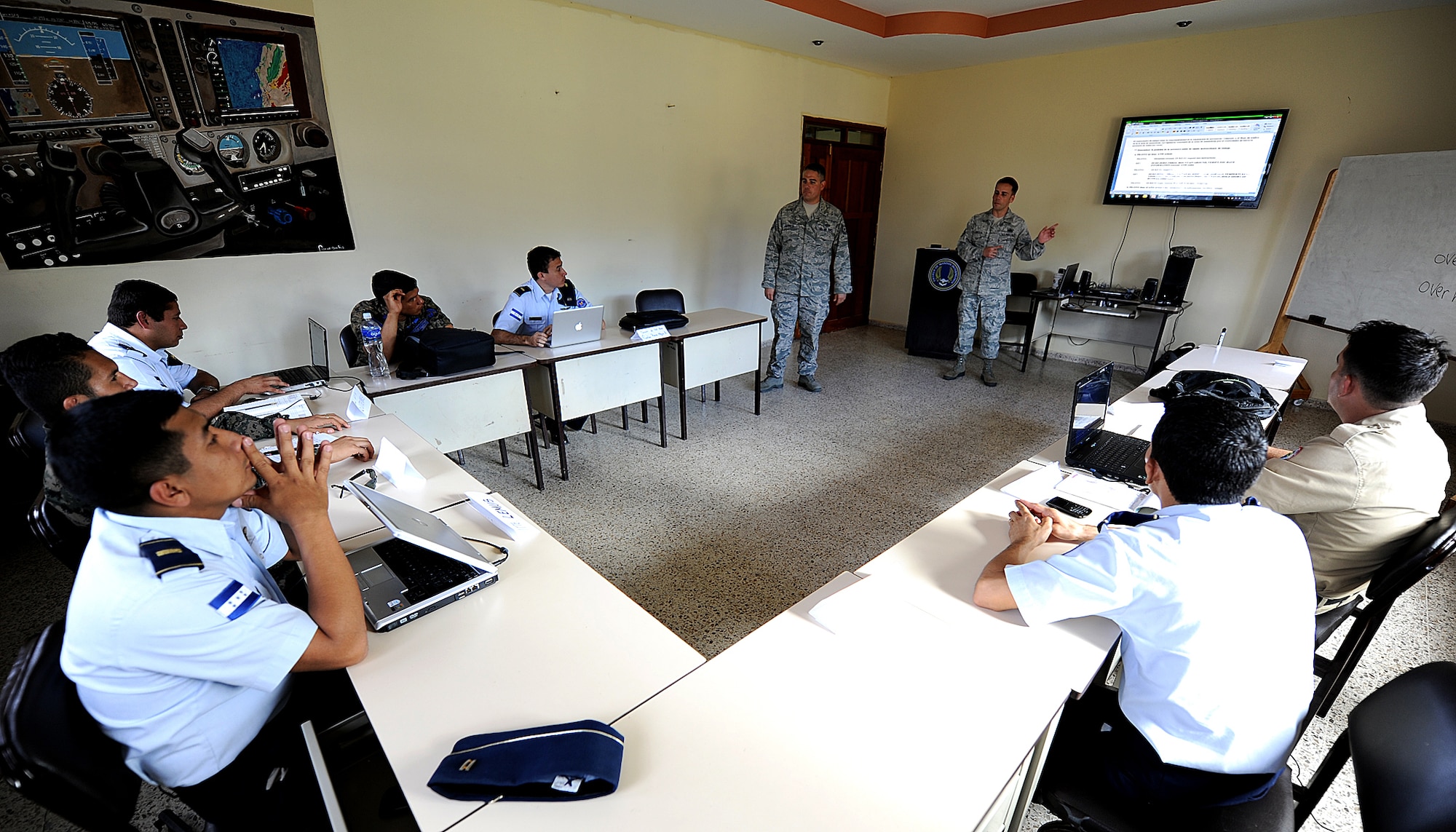 Staff Sgt. Angel Ortega, 571st Mobility Support Advisory Squadron air transportation air advisor, translates a section of the control tower fundamentals block for Tech. Sgt. Aaron Carrillo, 571 MSAS air traffic control air advisor, during the third week of ATC seminars Feb. 6.  The MSAS Airmen, alongside their Honduran Air Force counterparts, are participating in a month-long building partner capacity mission designed to enhance military-to-military relations between the two nations.  (U.S. Air Force photo by Tech. Sgt. Lesley Waters)