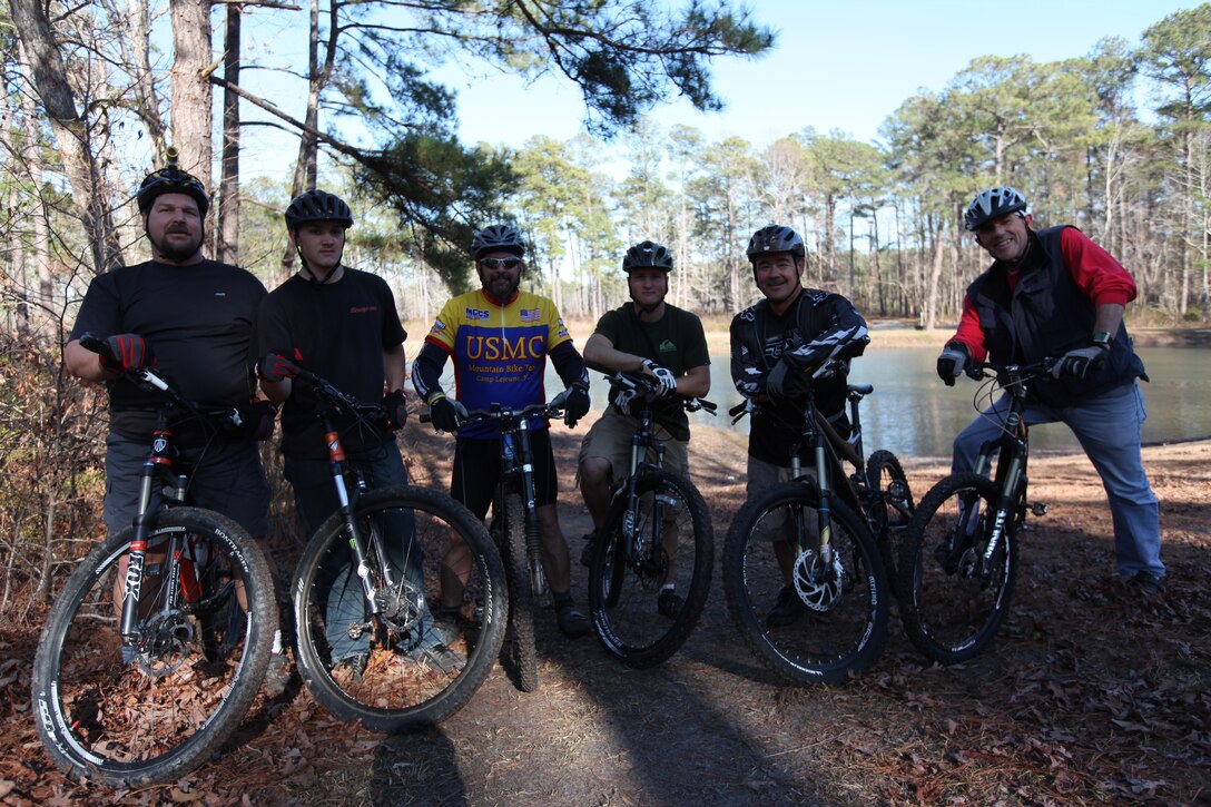 Marine Corp Base Camp Lejeune patrons and members of the Down East Cyclists Club take a break from biking the off-road trails near Henderson Pond aboard MCB Camp Lejeune, Feb. 20. Their volunteer work-force completed the first three-mile-long loop, which is now open for patrons to use.