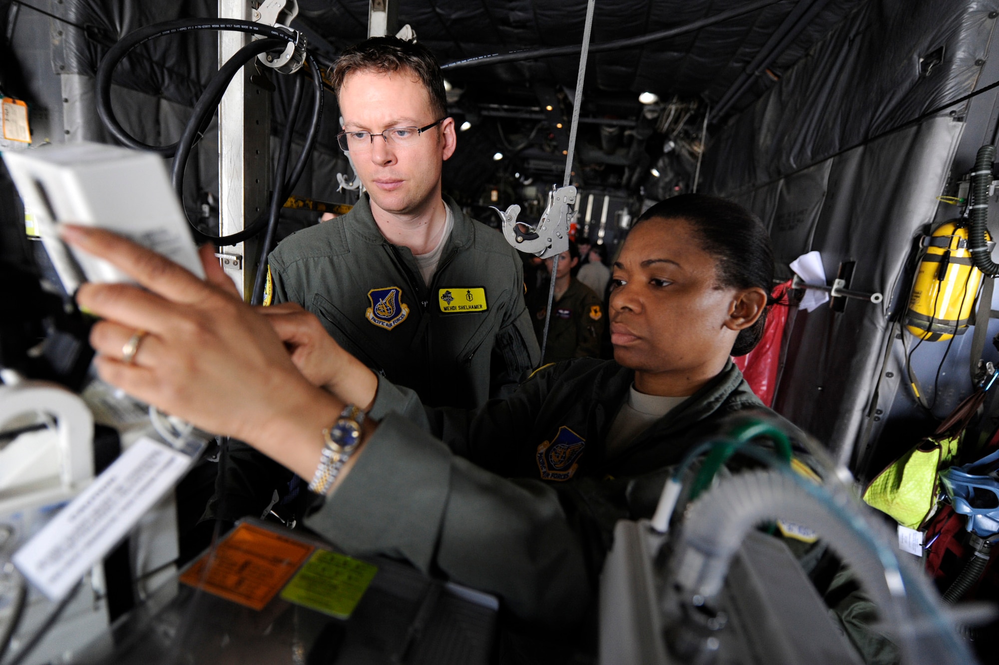 U.S. Air Force Maj. Mehdi Shelhamer, pulmonary and critical care physician, observes U.S. Air Force Capt. Tina Hall, critical care nurse, adjust medication doses during a routine training mission on a U.S. Air Force C-130 Hercules aircraft on Kadena Air Base, Japan, Feb. 14, 2012. Both are part of the Pacific Air Forces Critical Care Air Transport Team assigned to the 18th Medical Group. The CCATT provides care to critically ill or injured patients with multi-systems, trauma, shock, burns, respiratory failure, multiple organ failure, or other life threatening complications. (U.S. Air Force photo by James M. Bowman/Released)