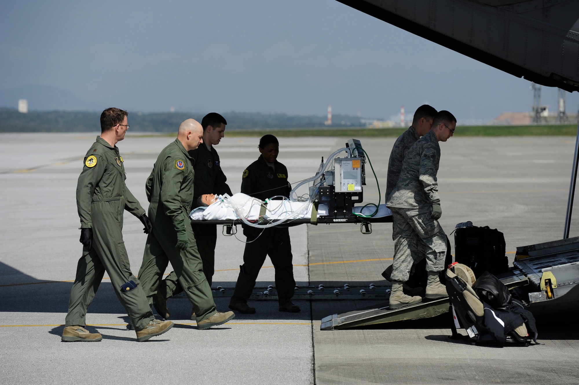 U.S. Air Force members assigned to the Pacific Air Forces Critical Care Air Transport Team and 18th Aeromedical Evacuation Squadron move a manikin onto a U.S. Air Force C-130 Hercules aircraft during routine training mission on Kadena Air Base, Japan, Feb. 14, 2012. The CCATT provides care to critically ill or injured patients with multi-systems, trauma, shock, burns, respiratory failure, multiple organ failure or other life threatening complications. The 18th AES delivers aerospace medicine services to enhance human performance and minimize the loss of valuable assets from disease and non-battle injuries. (U.S. Air Force photo by James M. Bowman/Released)