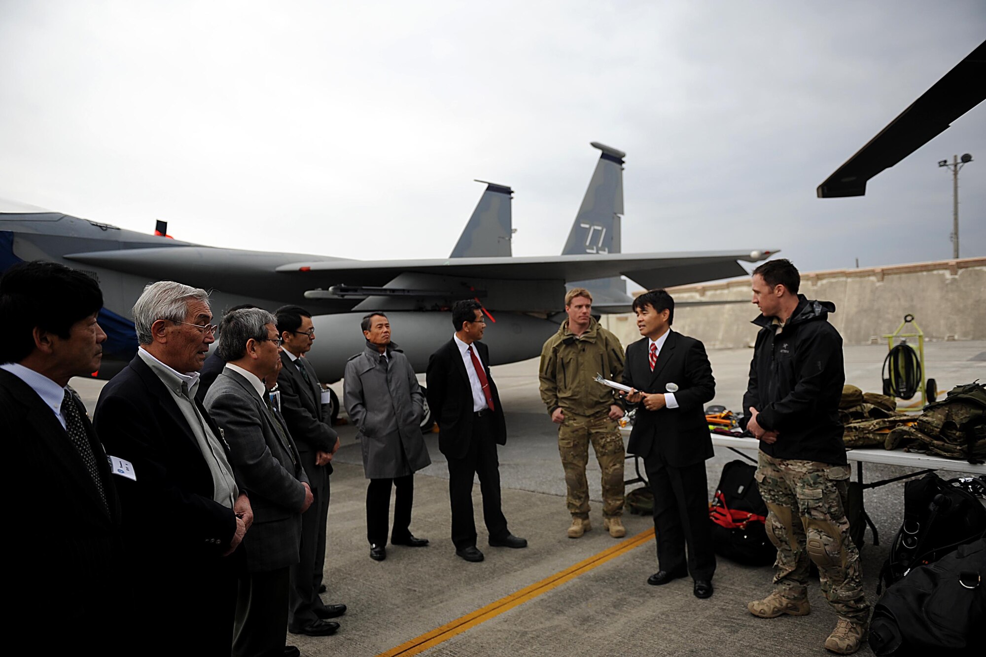 Hideaki Sakihama, 18th Wing Public Affairs community relations specialist, translates between U.S. service members and members of the Japan-American Air Force Goodwill Association during a tour of the flight line on Kadena Air Base, Japan, Feb. 17, 2012. Members of JAAGA visited Kadena in order to better understand the mission of the 18th Wing. (U.S. Air Force photo by Airman 1st Class Brooke P. Beers/Released)