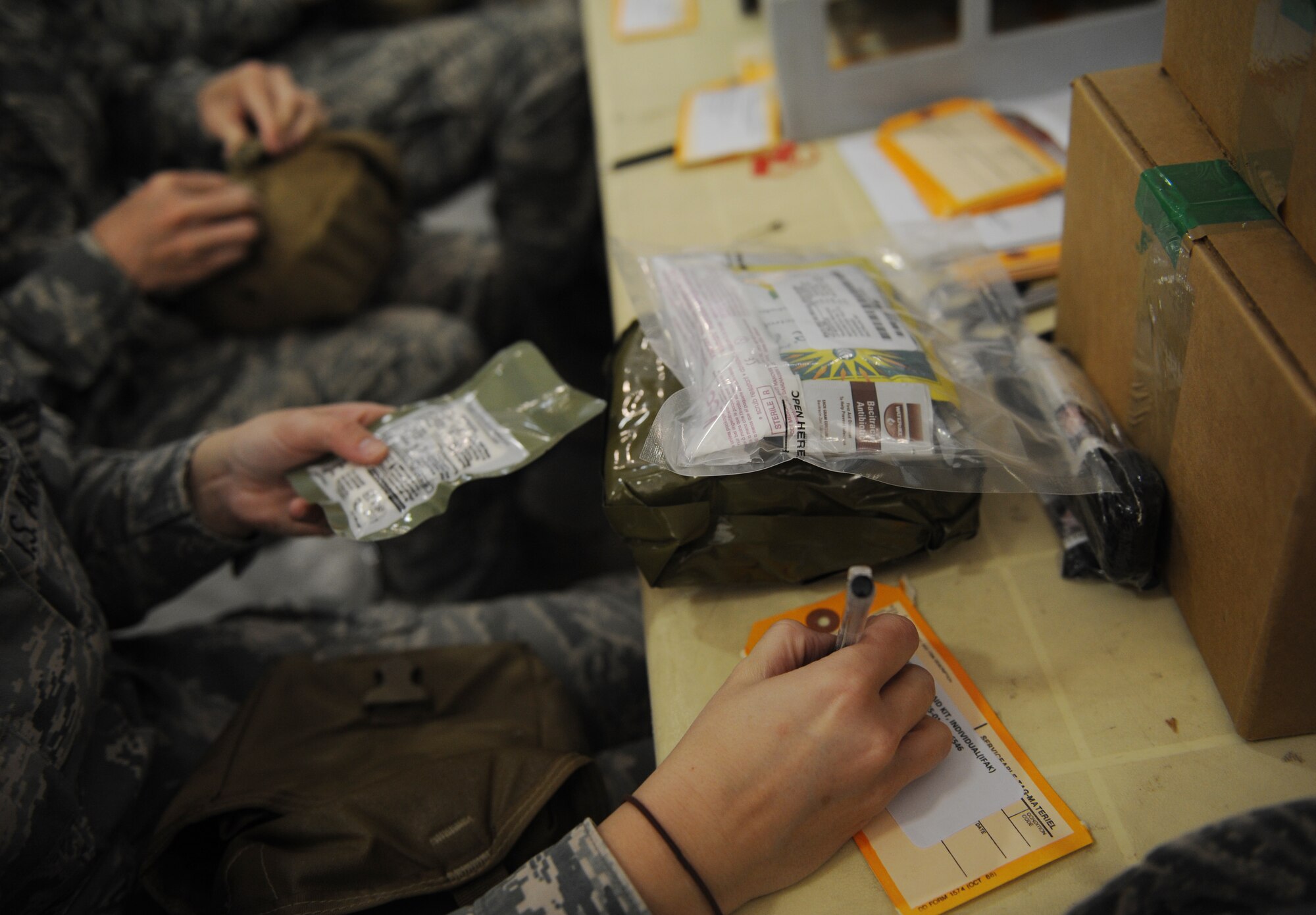 SOUTHWEST ASIA – A volunteer updates an individual first aid kit with the correct expiration date for items inside the IFAK here Feb. 14, 2012. The IFAKs are issued to all service members who deploy to Southwest Asia and other locations around the world. (U.S. Air Force photo/Staff Sgt. Nathanael Callon)