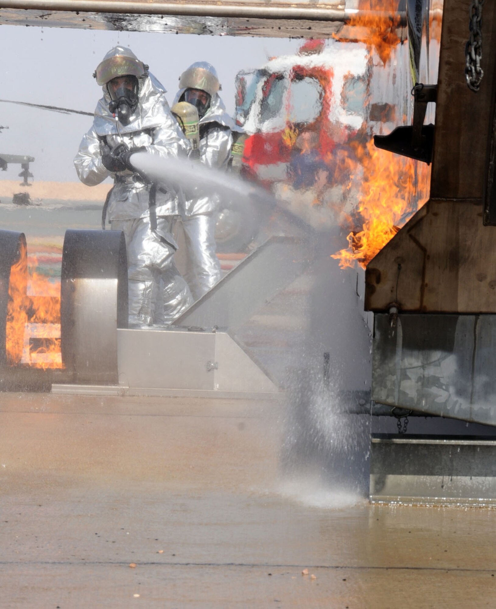 U.S. Air Force firefighters from the 386th Expeditionary Civil Engineering Squadron conduct aircraft rescue and fire fighting (ARFF) on an aircraft fire simulator on a flightline in an undisclosed location, Southwest Asia, Feb. 14, 2012. The 386th ECES firefighters were required to simulate extinguishing a structural fire and extract personnel to refresh their skills needed to perform in an emergency situation. (U.S. Air Force photo by Staff Sgt. James Lieth/Released)