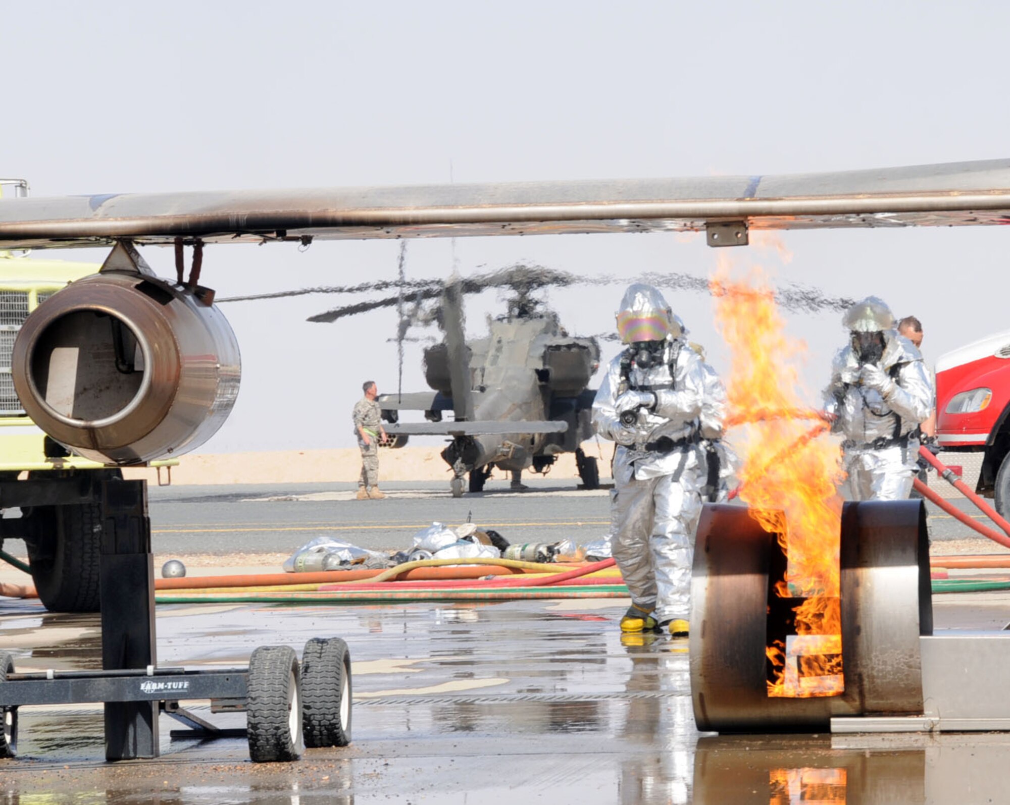 U.S. Air Force firefighters from the 386th Expeditionary Civil Engineering Squadron conduct aircraft rescue and fire fighting (ARFF) on an aircraft fire simulator on a flightline in an undisclosed location, Southwest Asia, Feb. 14, 2012. The 386th ECES firefighters were required to simulate extinguishing a structural fire and extract personnel to refresh their skills needed to perform in an emergency situation. (U.S. Air Force photo by Staff Sgt. James Lieth/Released)