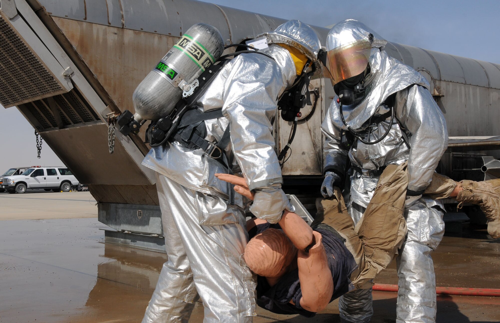 U.S. Air Force firefighters from the 386th Expeditionary Civil Engineering Squadron conduct aircraft rescue and fire fighting (ARFF) on an aircraft fire simulator on a flightline in an undisclosed location, Southwest Asia, Feb. 14, 2012. The 386th ECES firefighters were required to simulate extinguishing a structural fire and extract personnel to refresh their skills needed to perform in an emergency situation. (U.S. Air Force photo by Staff Sgt. James Lieth/Released)