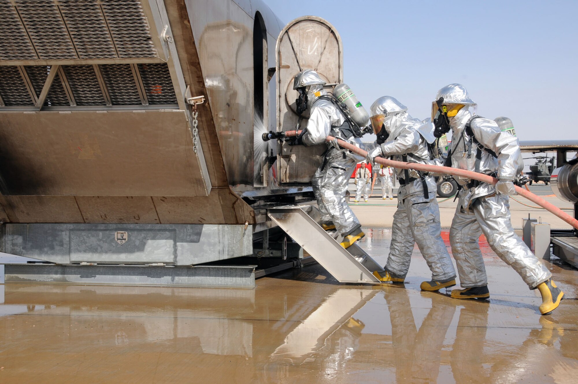 U.S. Air Force firefighters from the 386th Expeditionary Civil Engineering Squadron conduct aircraft rescue and fire fighting (ARFF) on an aircraft fire simulator on a flightline in an undisclosed location, Southwest Asia, Feb. 14, 2012. The 386th ECES firefighters were required to simulate extinguishing a structural fire and extract personnel to refresh their skills needed to perform in an emergency situation. (U.S. Air Force photo by Staff Sgt. James Lieth/Released)