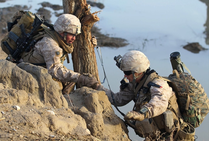 Petty Officer 3rd Class Victor Castro, a Navy corpsman with 2nd platoon, India Company, 3rd Battalion, 7th Marine Regiment, helps Lance Cpl. Josue Hernandez, a rifleman with 2nd platoon, climb up a ravine during a partnered patrol with the Afghan National Army, Feb. 20. Hernandez and Castro, both natives of San Francisco, joined with the rest of India Co. in a supportive role for the ANA. The Afghan soldiers leading and patrolling alone started a couple months ago after thorough mentorship and training by the Marines.