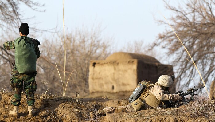 A Marine rifleman with India Company, 3rd Battalion, 7th Marine Regiment, post security with his Afghan National Army counterpart during a partnered patrol, Feb. 20. Over the last months India Co. has transferred some of their responsibility to the ANA in preparation for when Coalition Forces withdraws from Afghanistan. The company has mentored and tutored the ANA soldiers in patrolling, house clearing and security since they arrived last year.