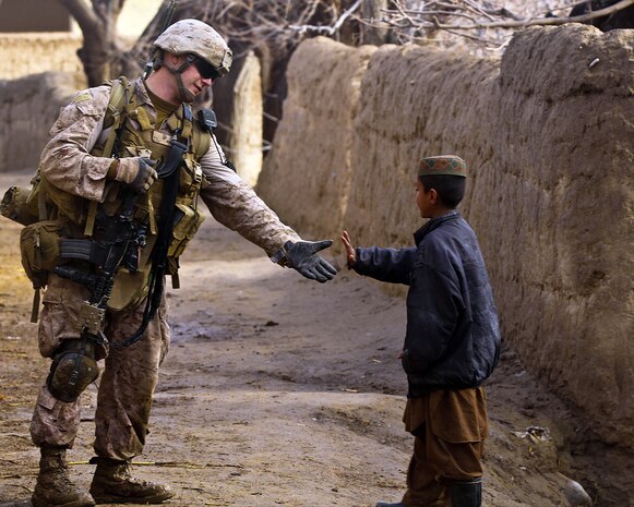 Cpl. Michael Greenleaf, a radio operator with 3rd platoon, India Company, 3rd Battalion, 7th Marine Regiment, high fives an Afghan child during the company’s partnered patrol with the Afghan National Army, Feb. 20. The company patrolled in support of the ANA through an area south of Patrol Base Hangar, encountering enemy insurgents and interacting with the local people. The ANA are preparing to take over the area once Coalition Forces withdraw Afghanistan.