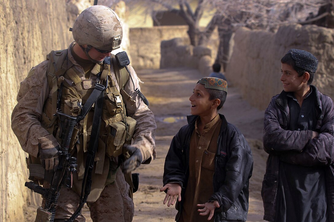 A local Afghan boy jokes with Cpl. Michael Greenleaf, a radio operator with 3rd Platoon, India Company, 3rd Battalion, 7th Marine Regiment, Feb. 20. India Company’s Marines trained the ANA to patrol on their own and with the Marines in a supporting role. The ANA encountered enemy fire during the patrol and responded quickly, repelling the attack. The Marines mentored the Afghan soldiers since they arrived at the patrol base late last year.
