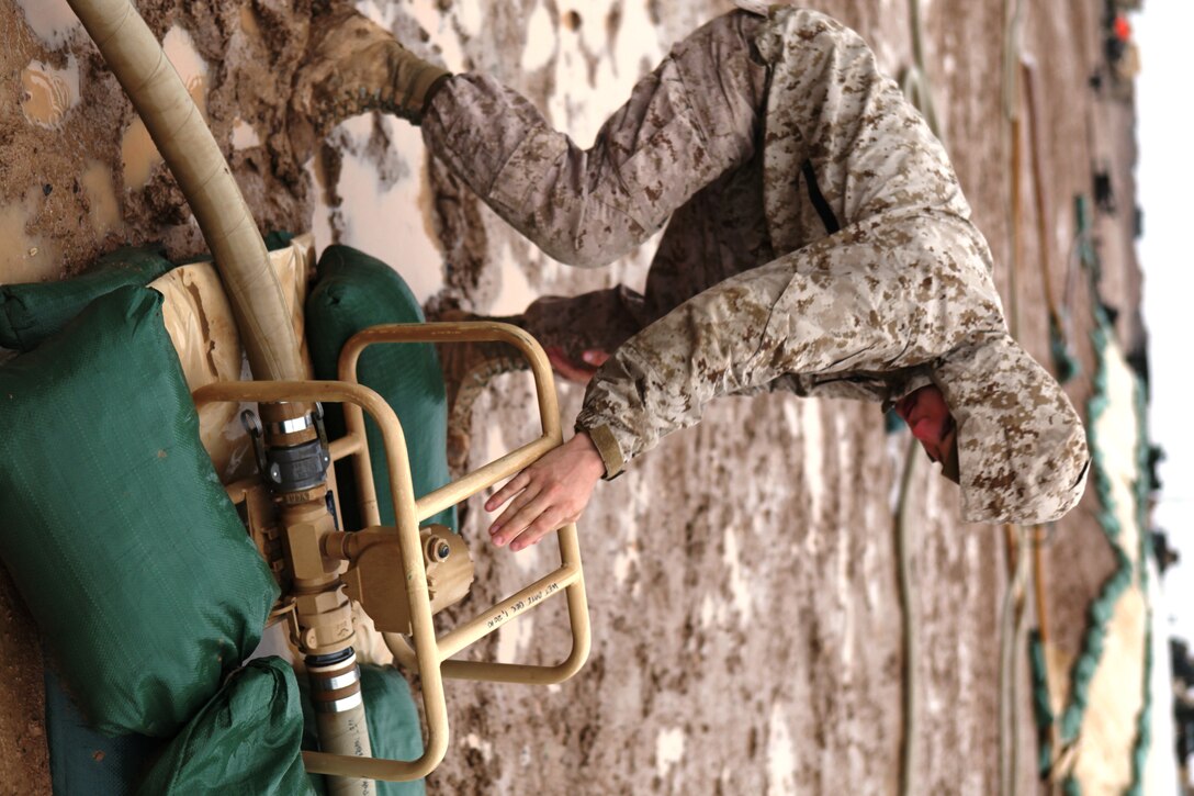 Lance Cpl. William Zerr, a bulk fuel specialist with Headquarters and Service Company, 9th Engineer Support Battalion, 1st Marine Logistics Group (Forward), checks the fuel gauges at Forward Operating Base Edinburgh Feb. 20. The bulk fuel Marines receive, store and dispense all of the ground and air fuel at FOB Edinburgh.