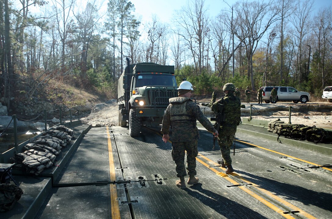 A Canadian national guardsman escorts a vehicle on a bridge during a training exercise with Bridge Company, 8th Engineer Support Battalion, 2nd Marine Logistics Group at Engineer’s Point aboard Camp Lejeune, N.C., Jan. 6, 2012. Throughout the exercise, the Canadians operated watercraft, manned safety boats and provided security for the scenarios. (U.S. Marine Corps photo by Pfc. Franklin E. Mercado)